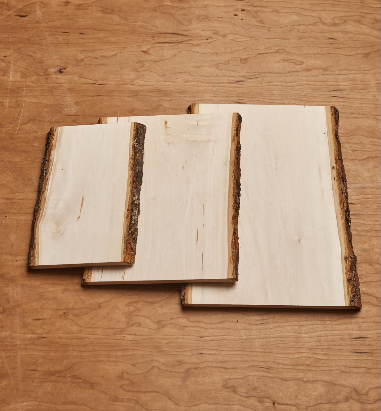 Les trois plaques rectangulaires en tilleul avec écorce de différents formats superposées pour comparer leurs dimensions