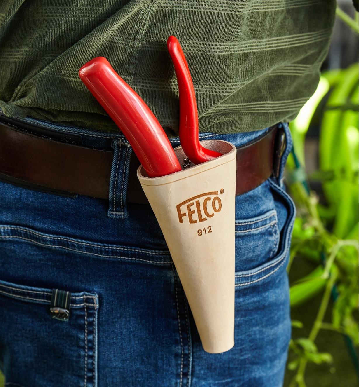 A clip holster for pruners is worn on a belt and holds a hand  pruner