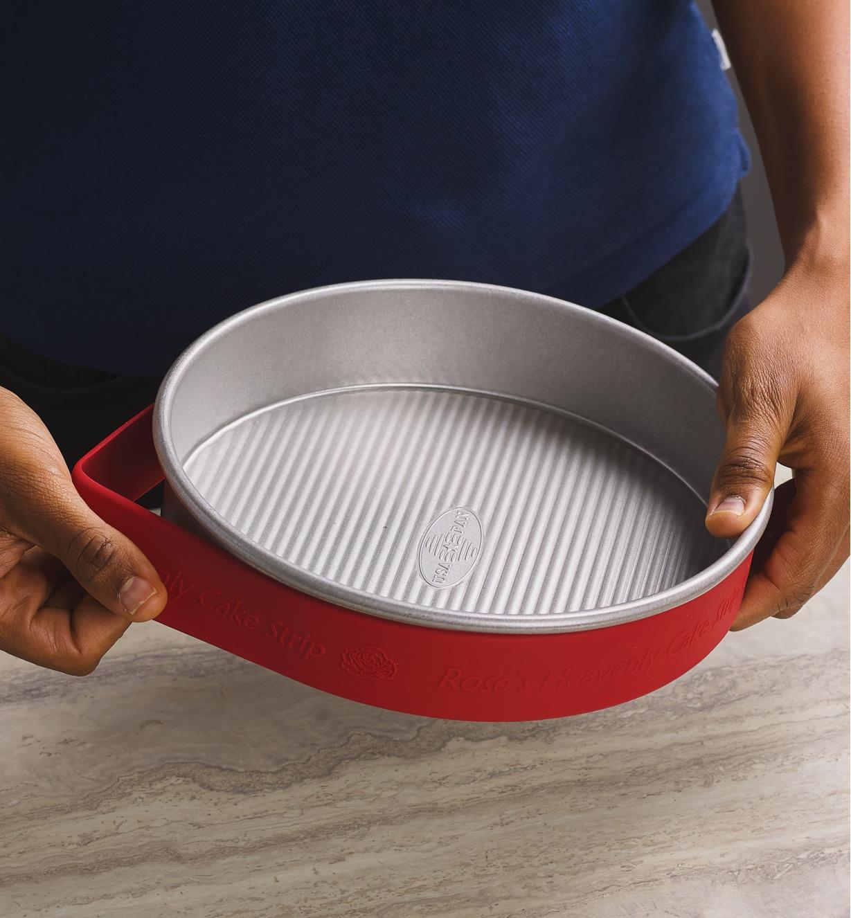 Placing a silicone cake strip around the outside of a circular cake pan