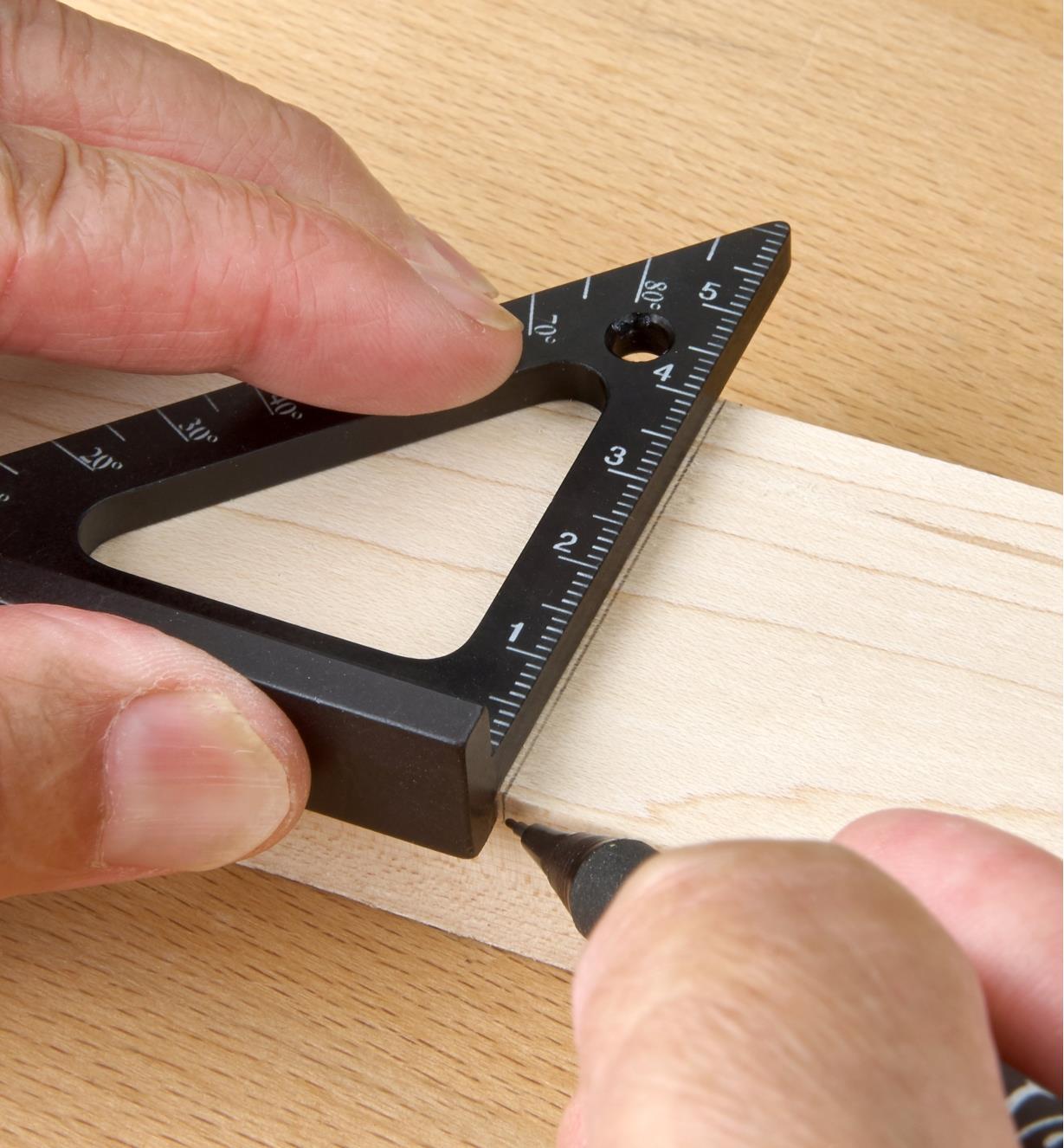 Registering a 60mm Pocket Layout Square against the edge of a workpiece while marking a cut line
