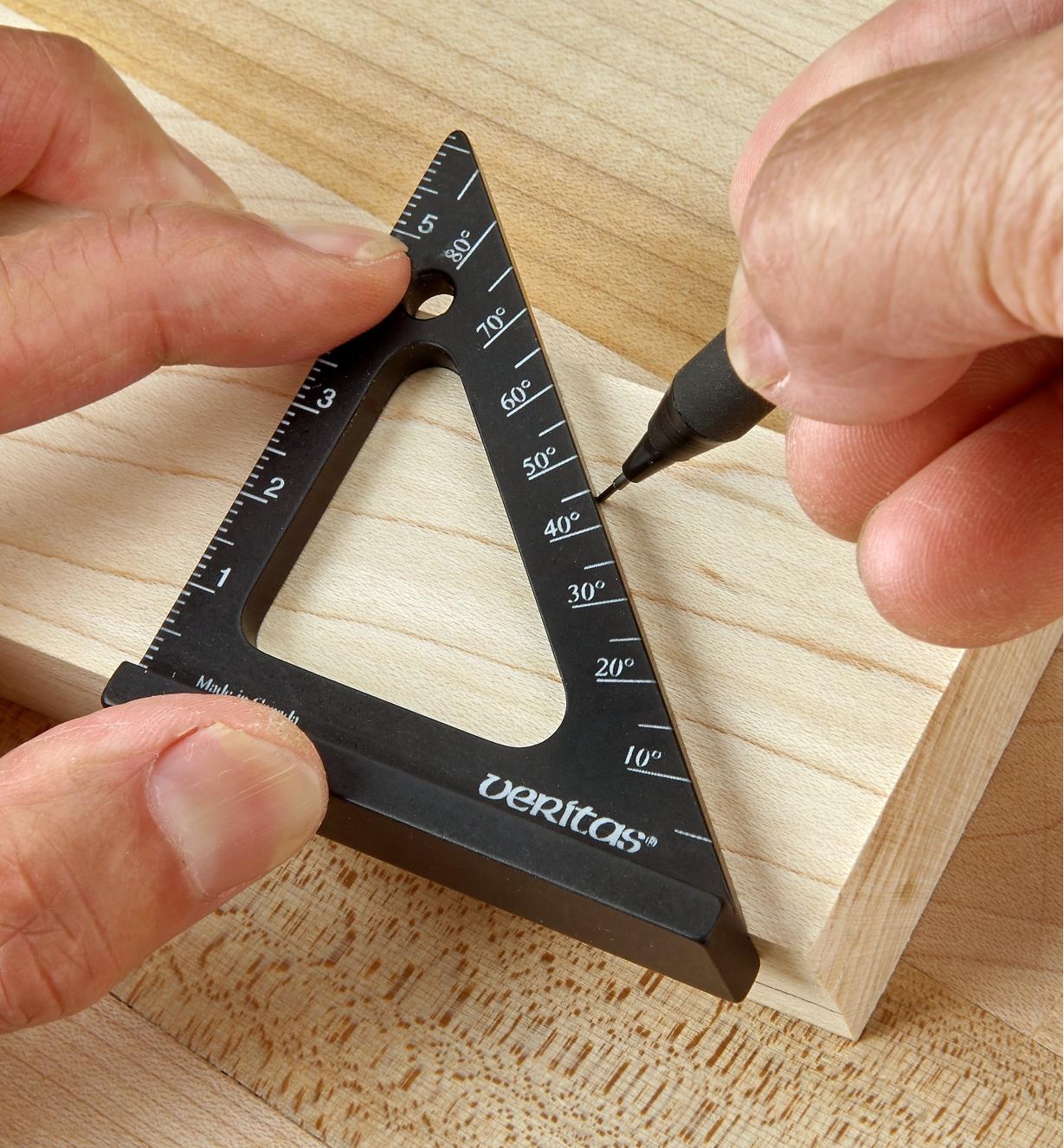 Marking against the 45° side of a 60mm pocket layout square with a pencil to lay out a miter cut