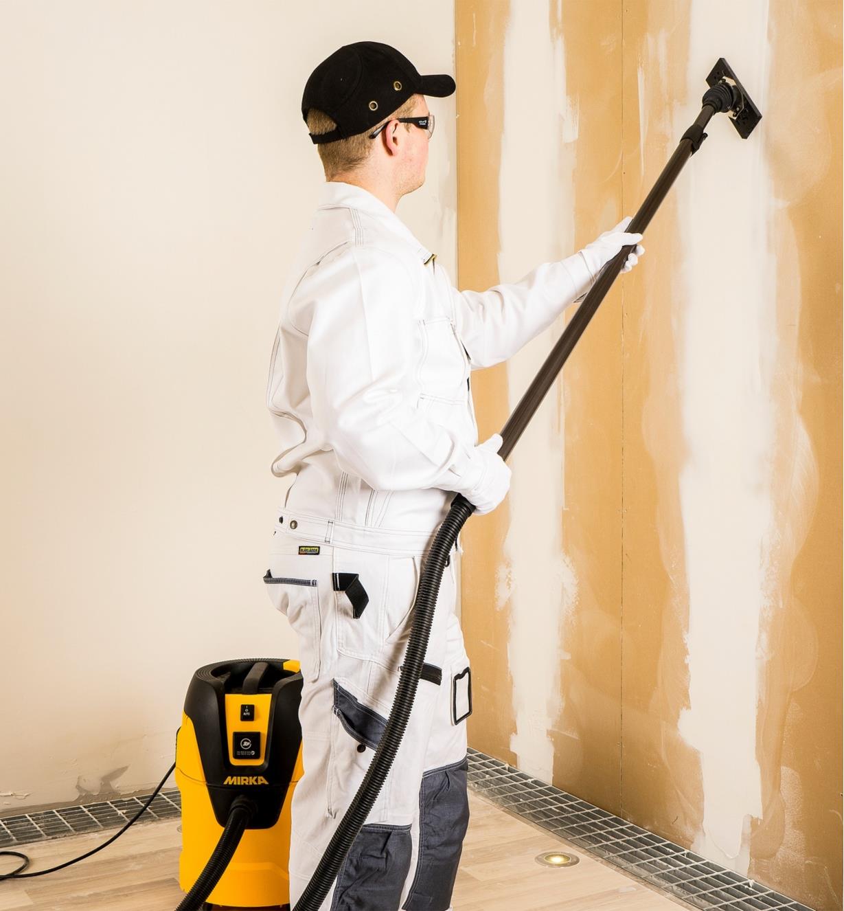 Using a Mirka DECO sander connected to a Mirka dust extractor to sand drywall