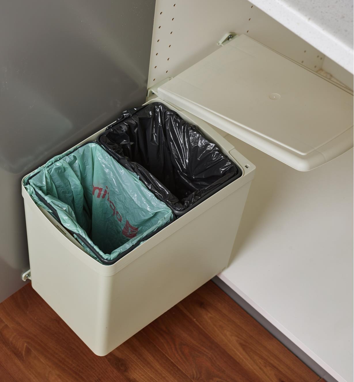 Dual waste container installed inside a kitchen cupboard