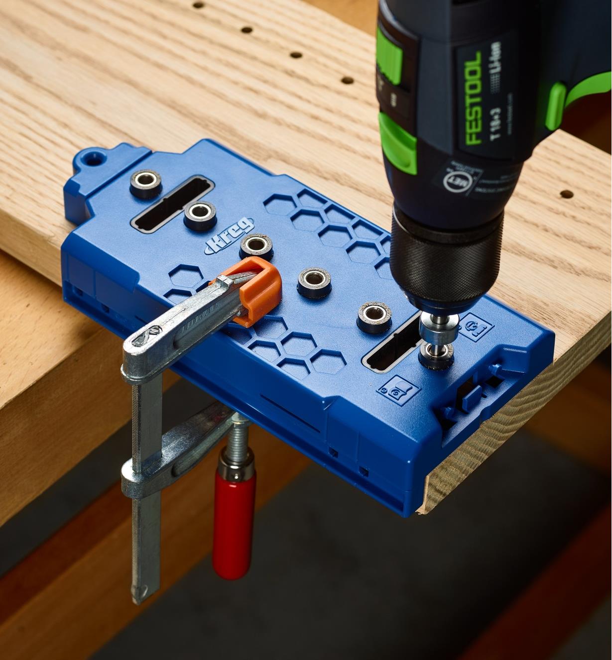 A jig clamped to a board as shelf pin holes are being drilled