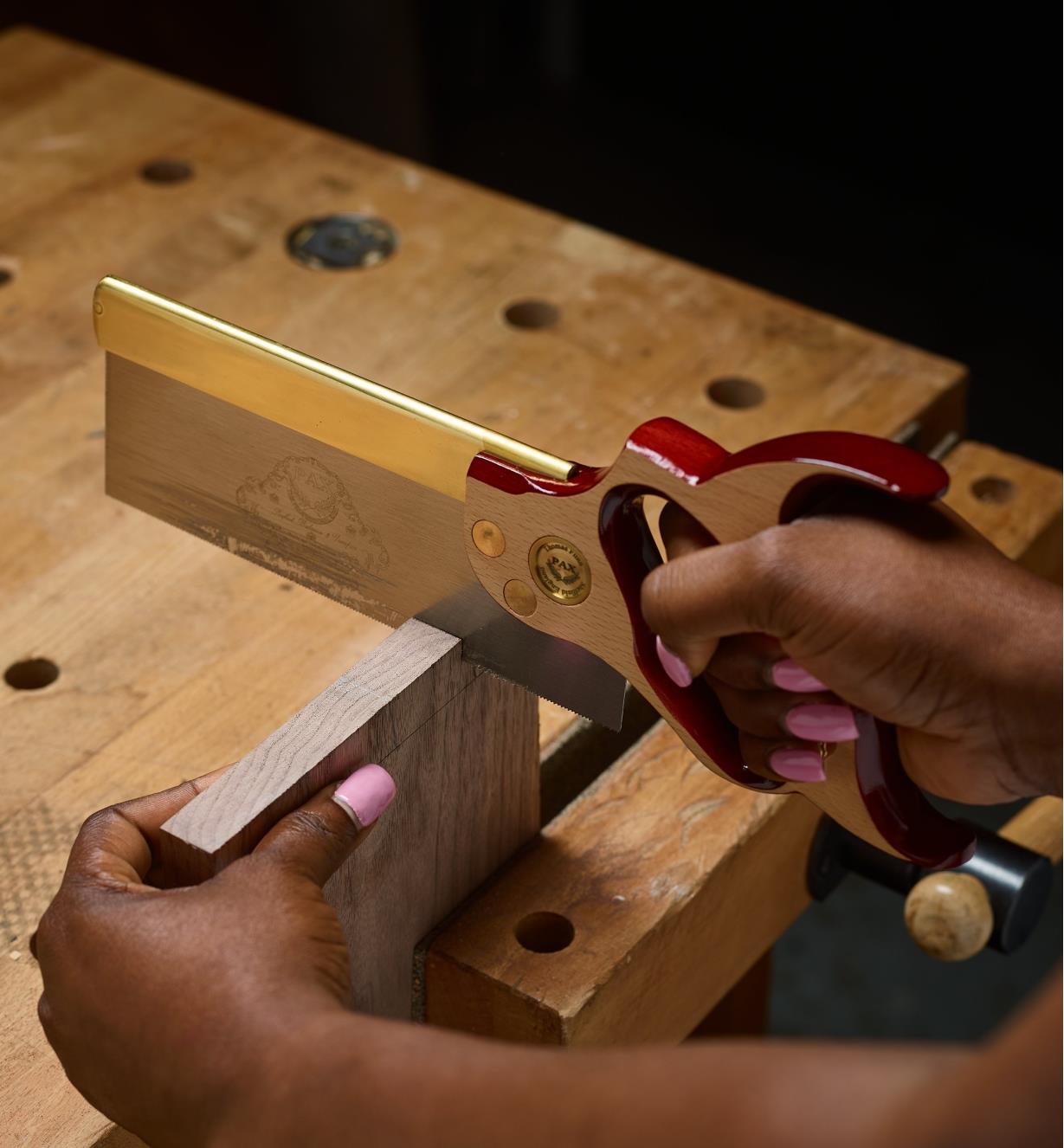 Using a dovetail saw to cut a board that is clamped in a vise
