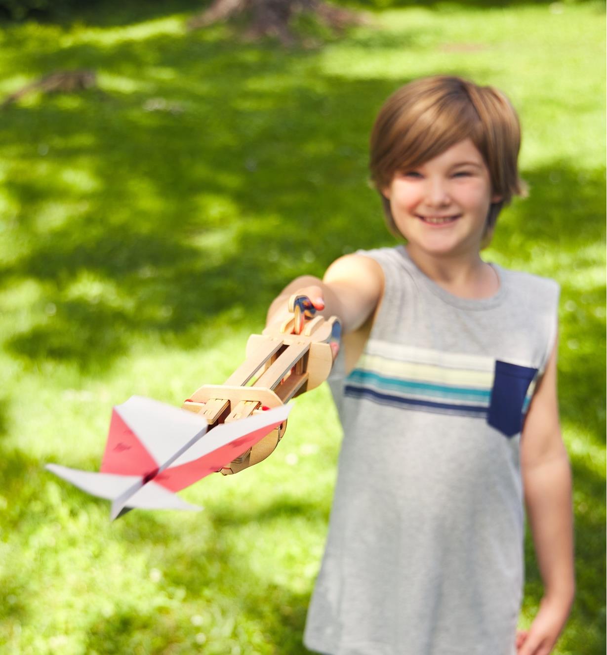 Enfant lançant un planeur en papier avec une catapulte pour planeur en papier