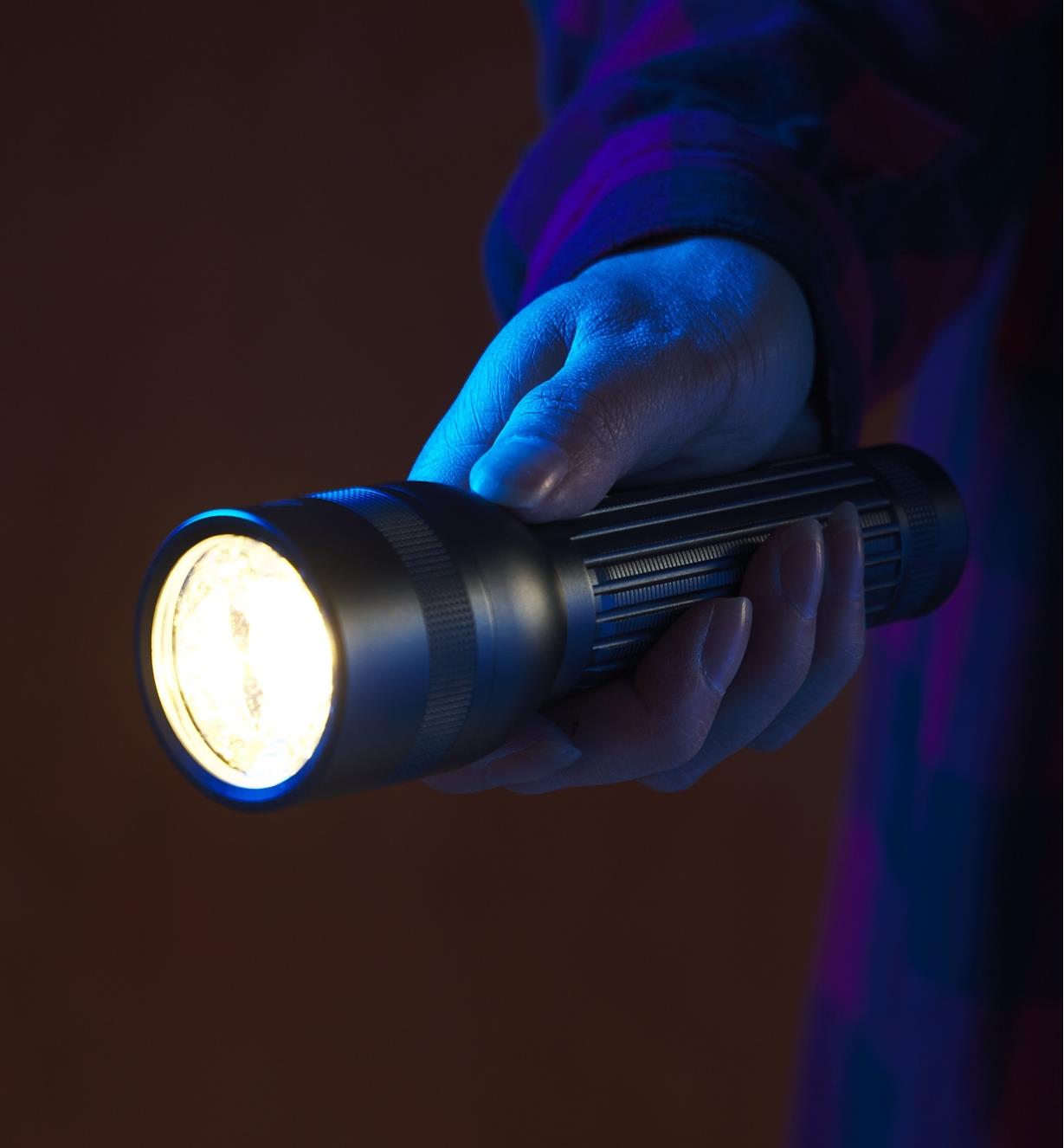 A person is holding a bright flashlight