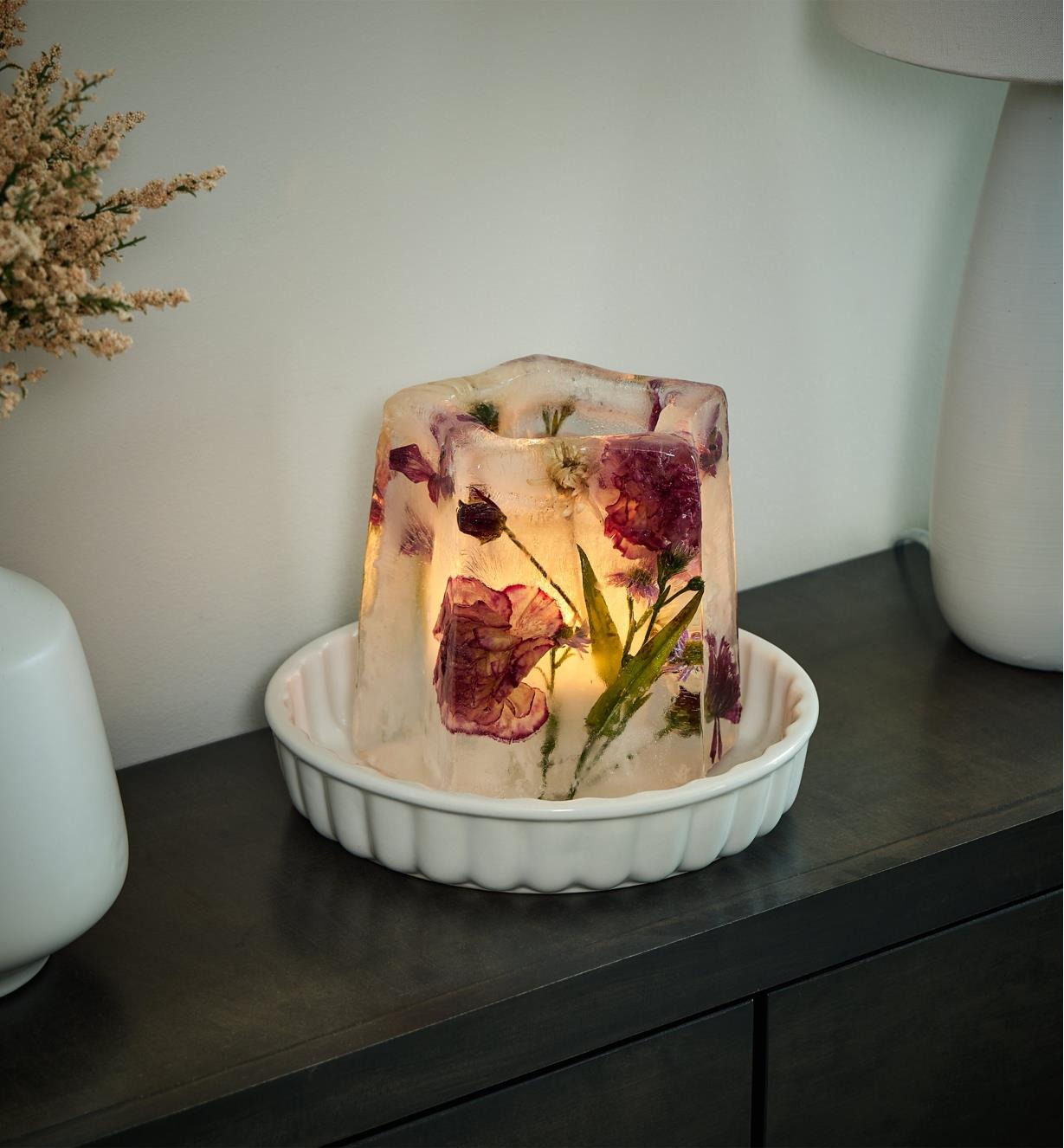 Ice lantern with flowers and greenery frozen inside