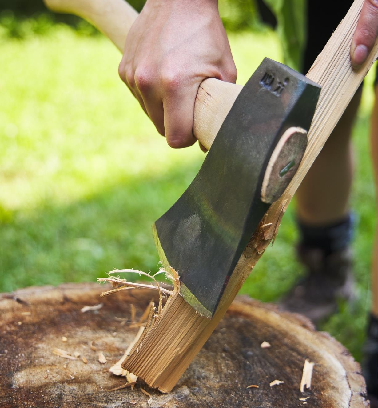 A hatchet being used to create a feather stick