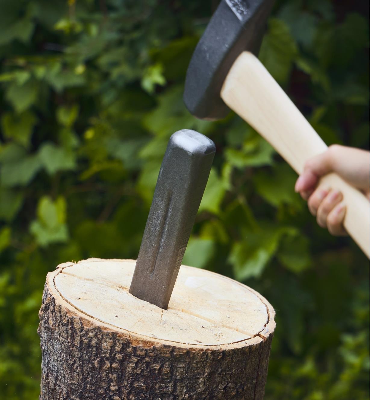 A square head wedge being used to split a round of wood