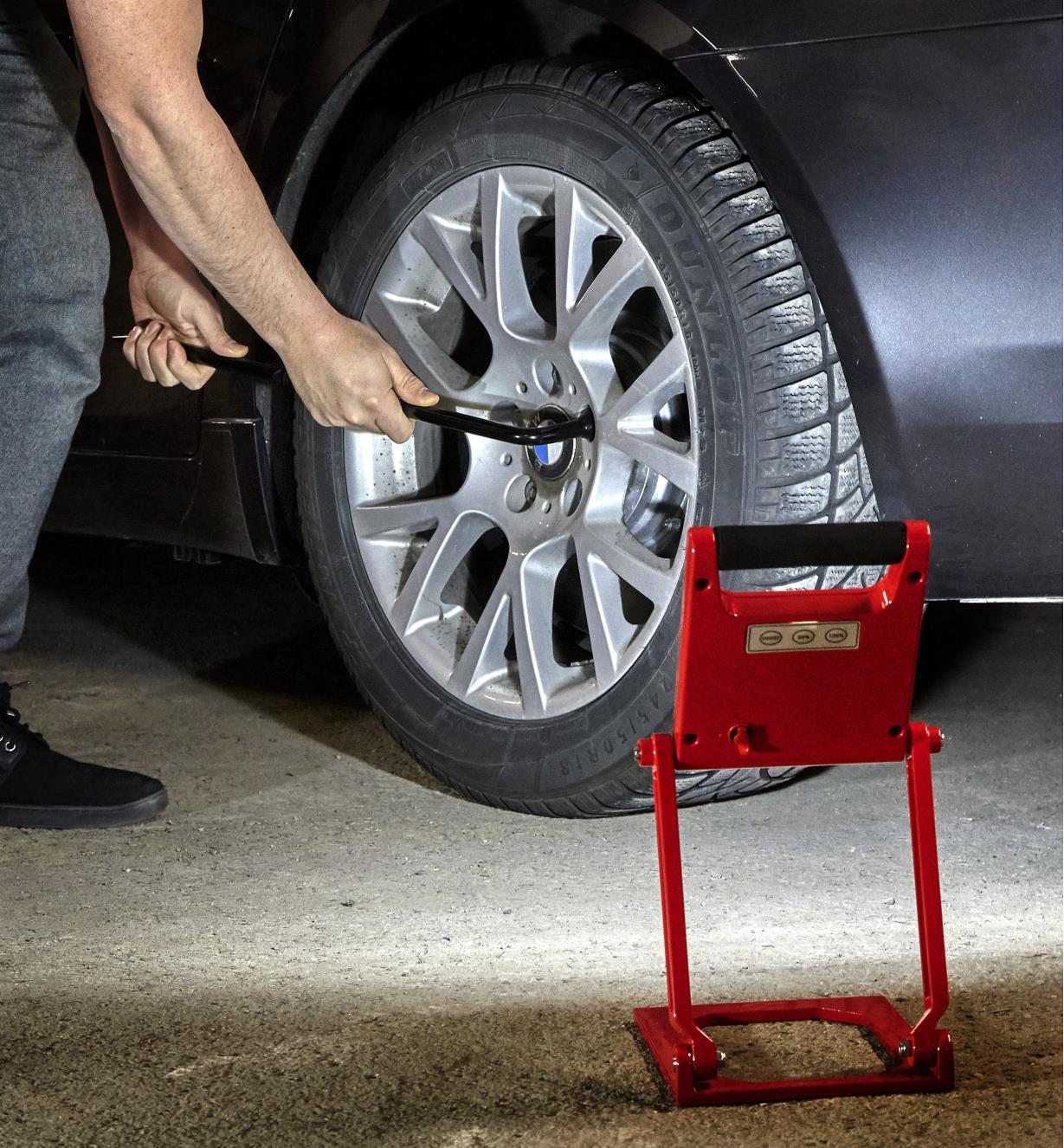 Using a folding rechargeable LED floodlight when changing a tire at night