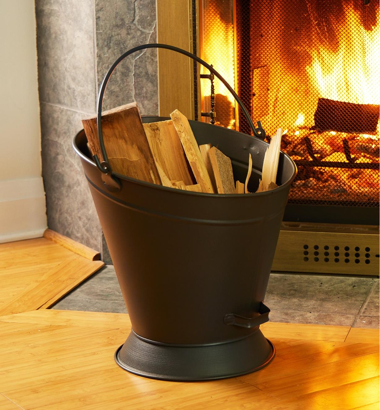 The coal scuttle containing kindling sits near a fireplace