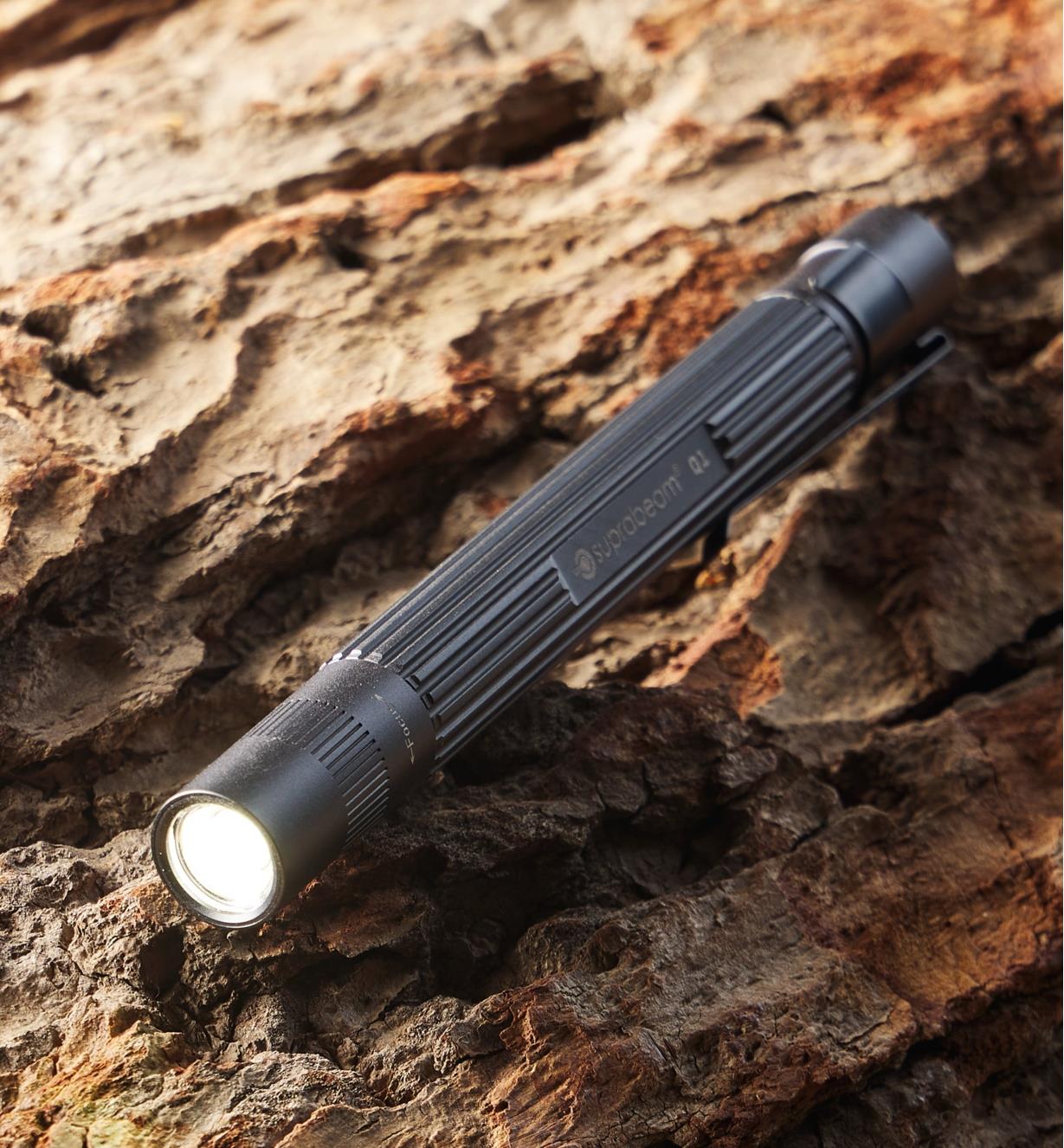 Lampe-stylo Q1 sur un fond d'écorce d'arbre