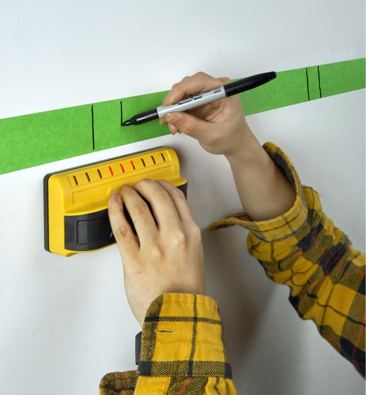 Using a Franklin M90 stud detector to mark the outlines of stud locations in a finished wall