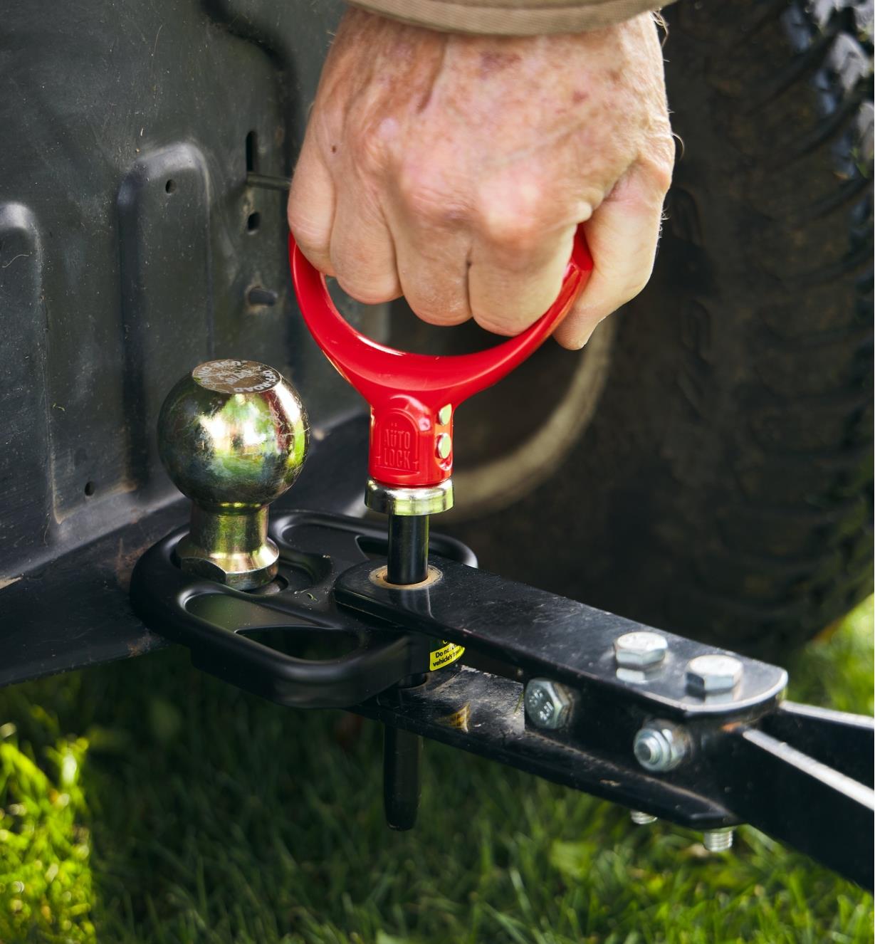 A magnetic hitch pin being removed from a trailer hitch