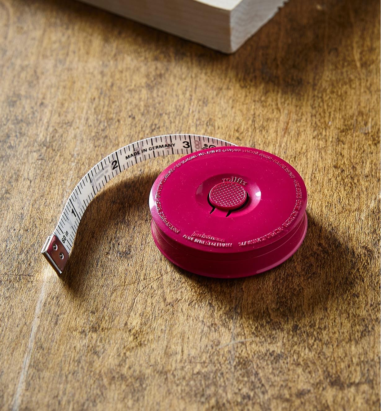 Ruban à mesurer de poche sur une table près d'un bout de bois