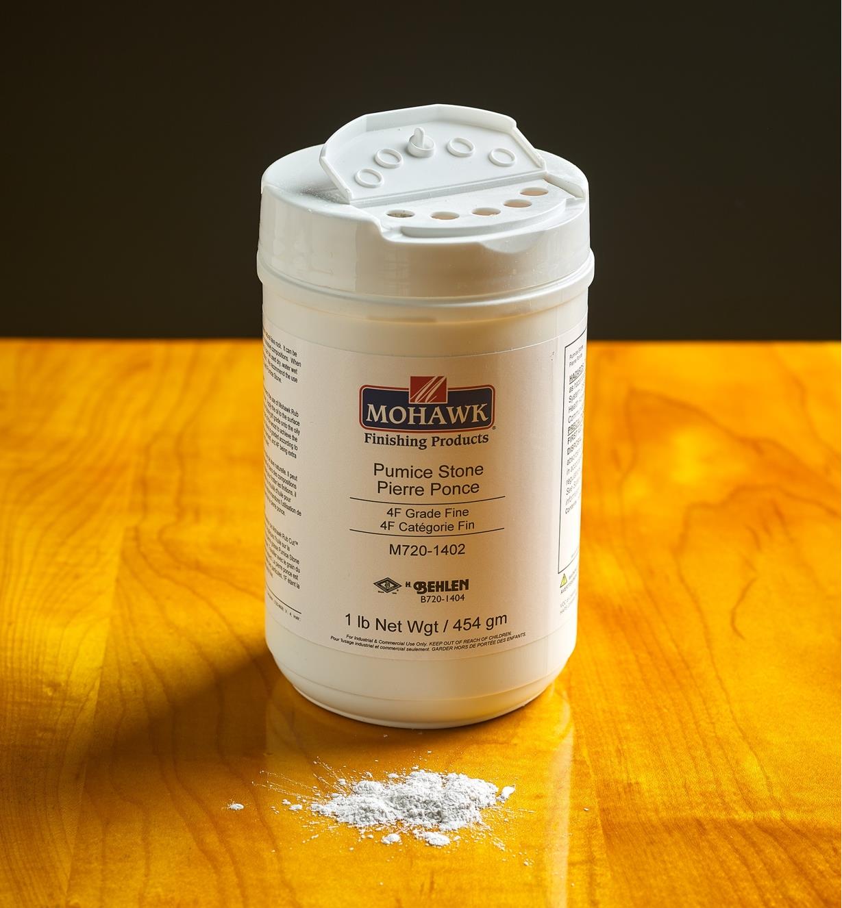 An open container of pumice stone with a small amount of powder on a table top