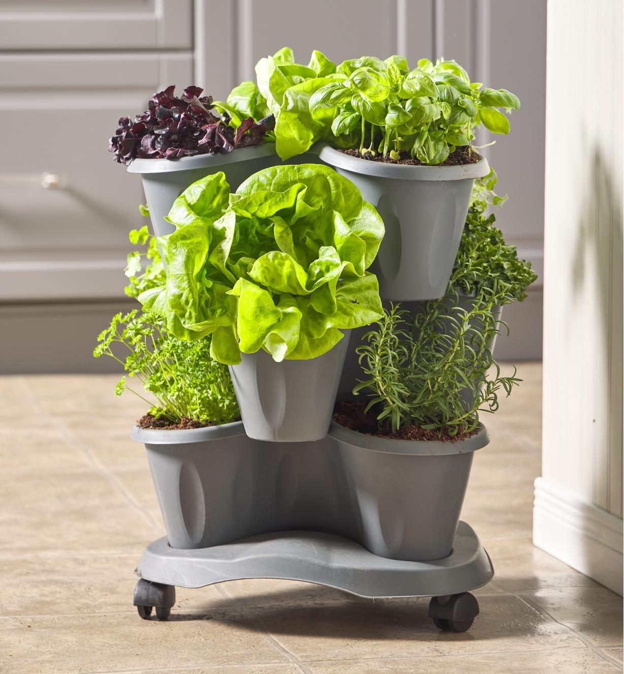 A three-level planter full of plants on a kitchen floor