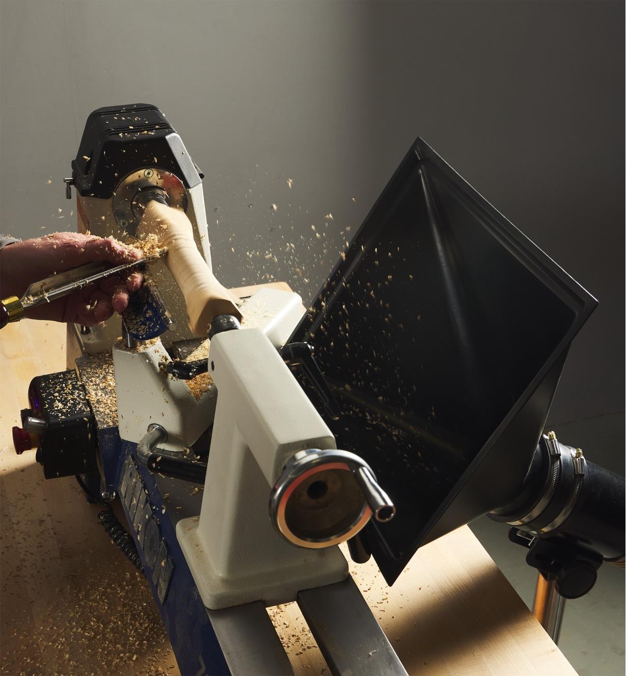 An extra-large dust hood collecting wood shavings from next to a lathe