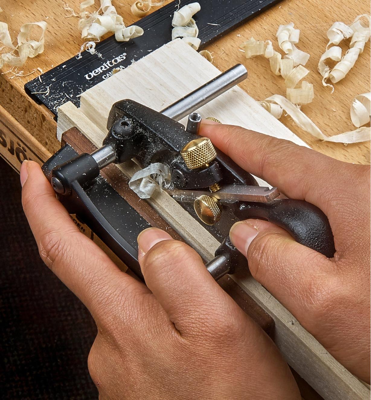 A right-hand box-maker’s plow plane being used to cut a groove on a piece of wooden stock