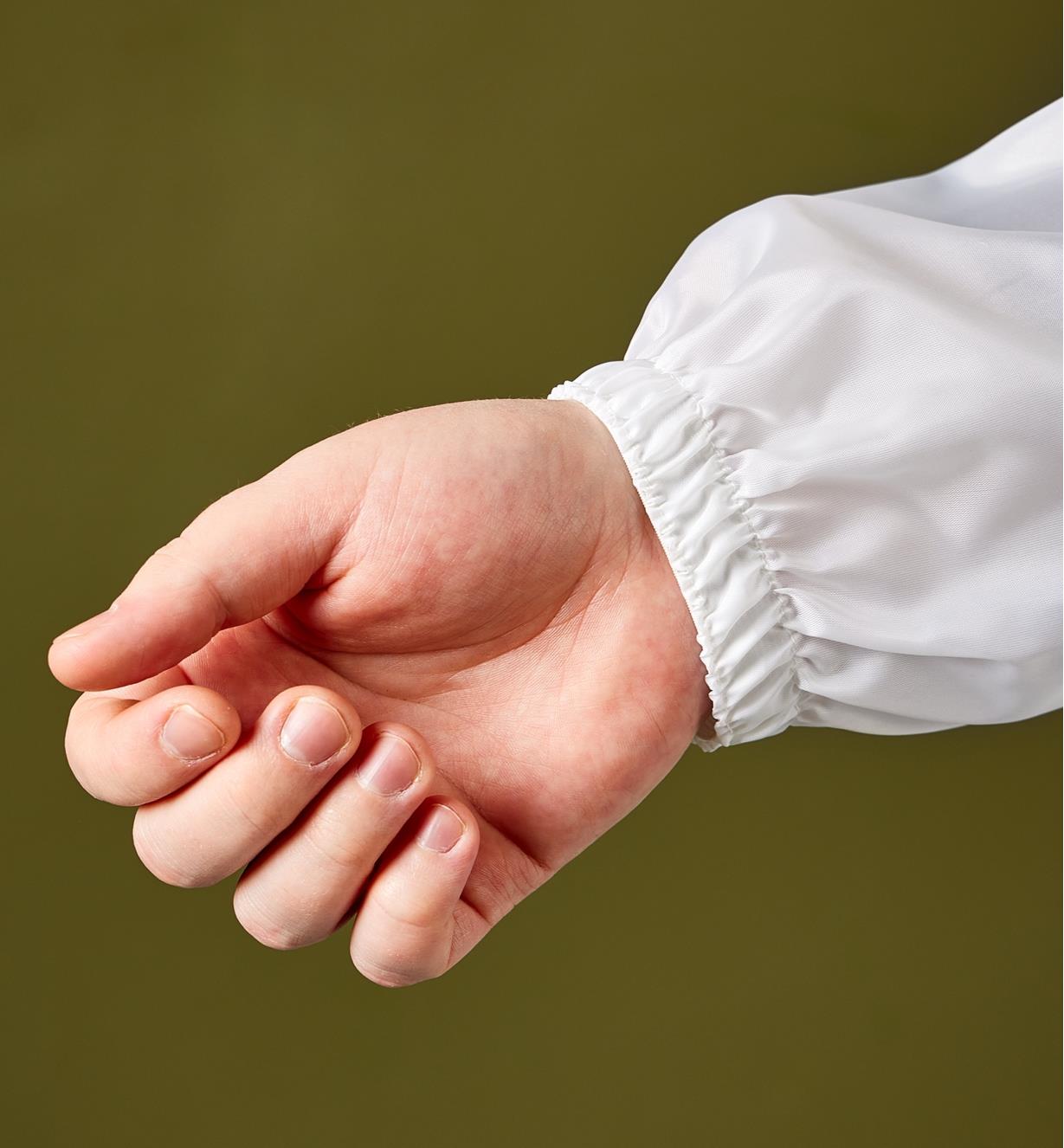 Close-up of the coverall sleeve cuff on a person’s wrist 