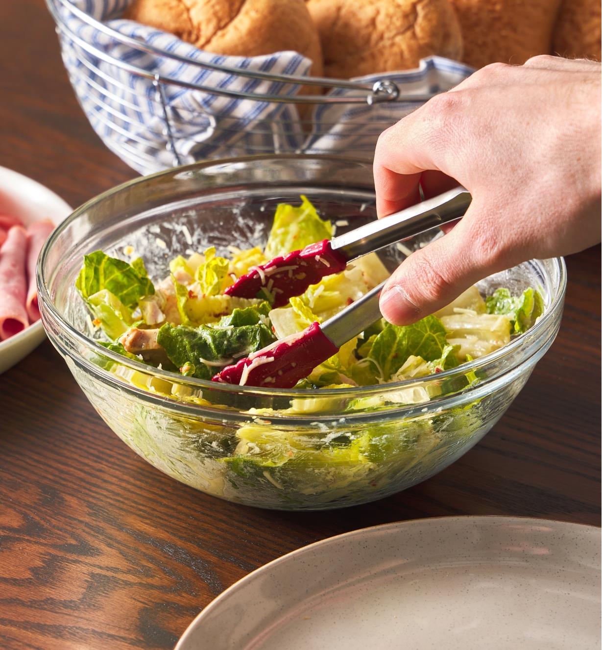 Using mini tongs to pick up salad from a bowl