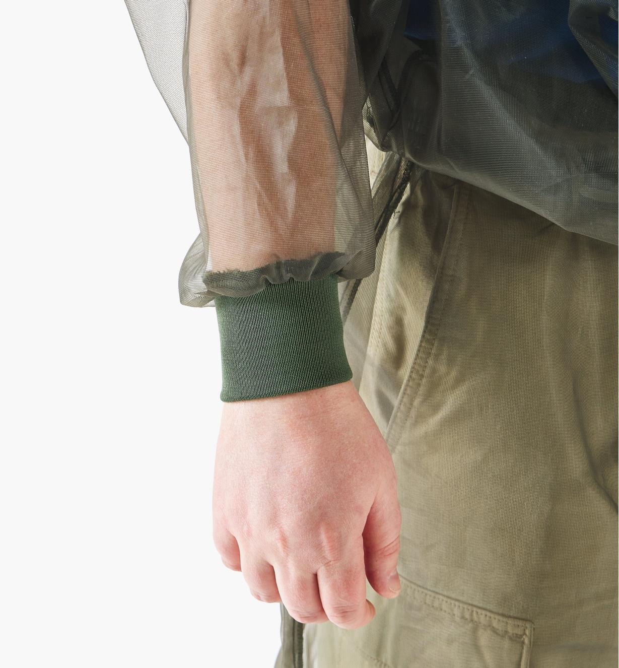 A close-up view of a full-width rib-knit wrist cuff on a hooded bug-protection shirt worn by a man