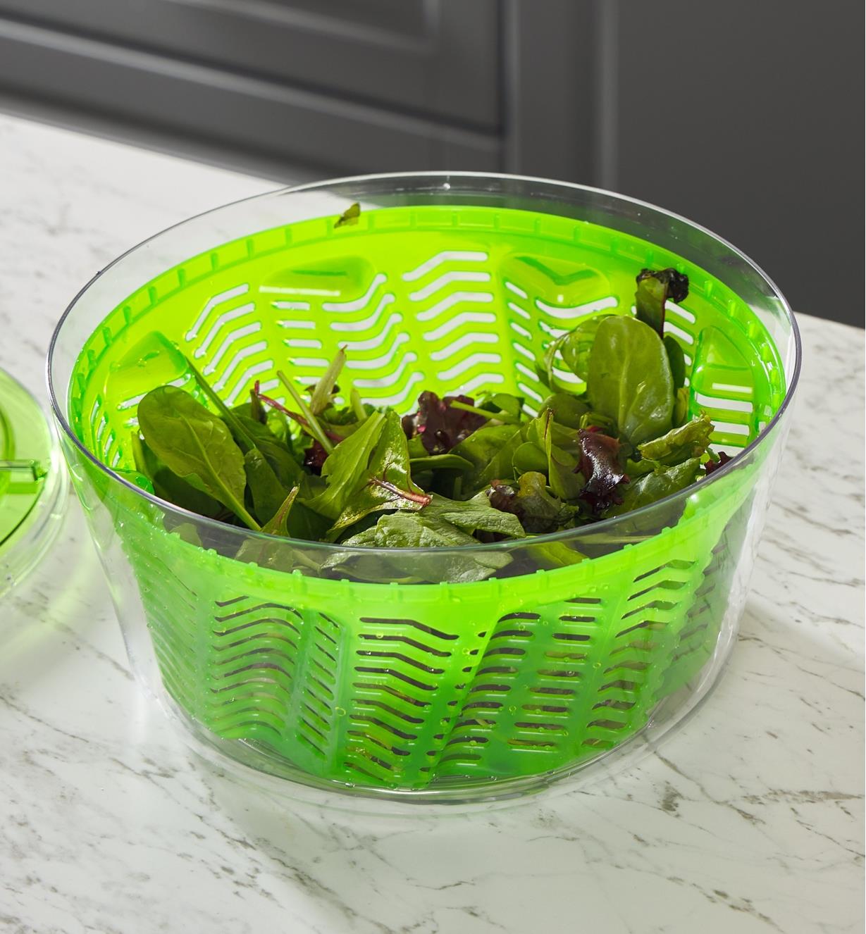 A salad spinner full of lettuce with the lid off