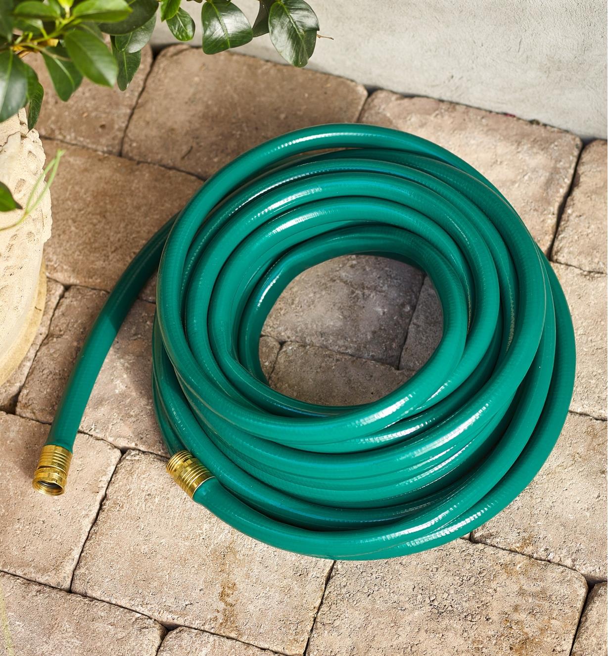A hose coiled on patio stones