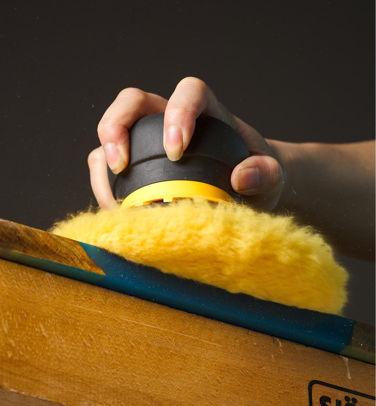 Polishing a wood surface with a Mirka 6" yellow lamb's wool pro pad affixed to a 6" orbital sander and polisher
