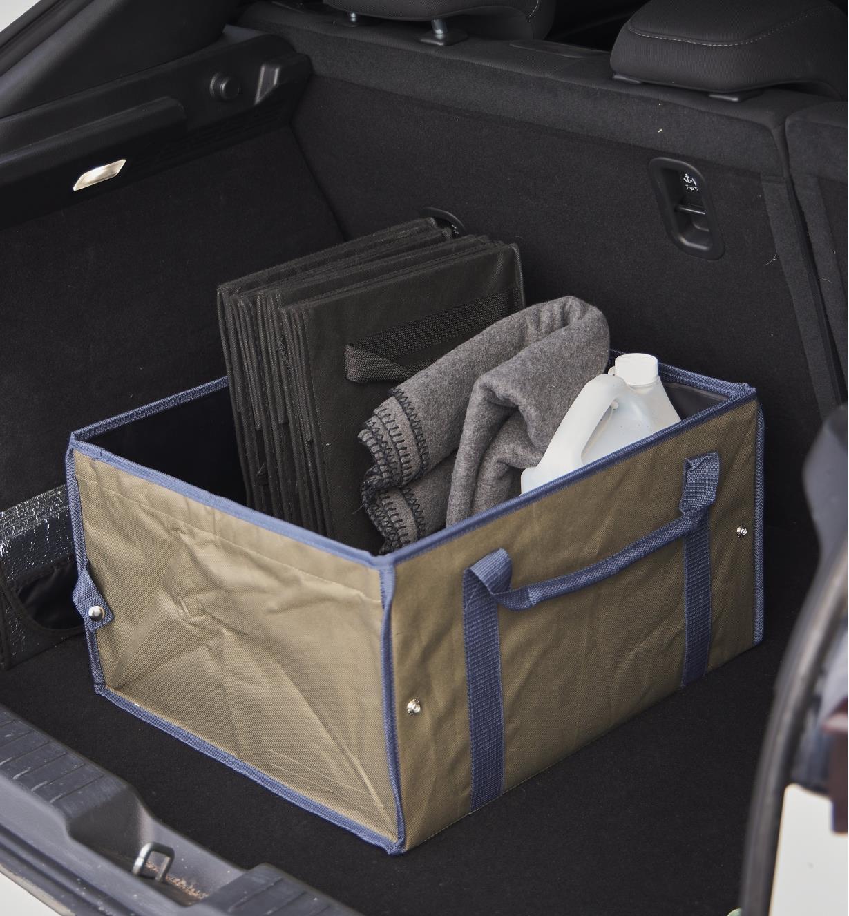 A large trunk organizer filled with items in the cargo area of a car