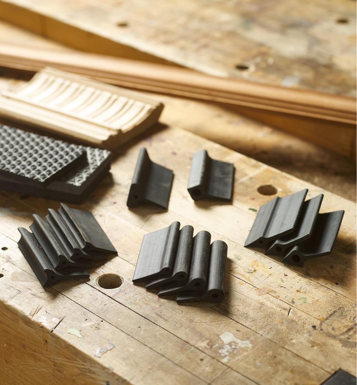 A set of 15 contour sanding grips of various profiles on a workbench