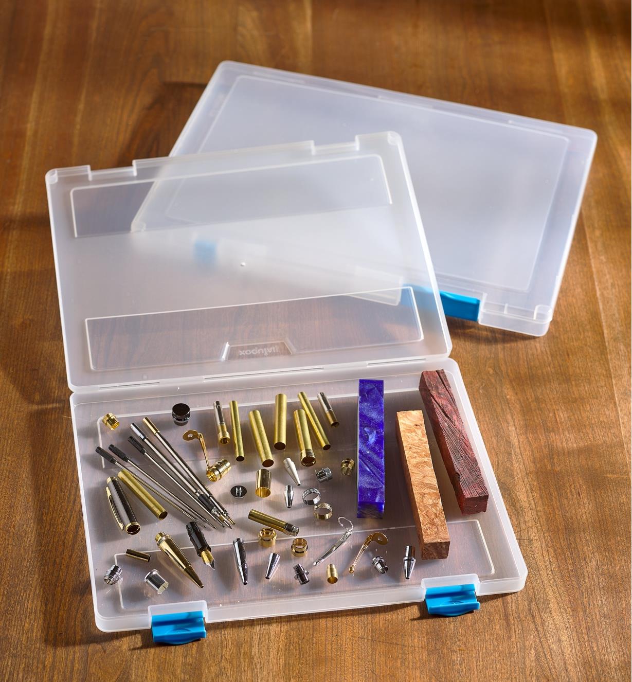 A letter-size case full of pen-turning supplies lying on a table beside an empty legal-size case