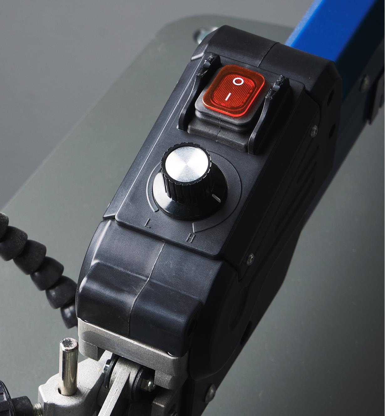 The power switch and speed control knob on the bevel at the front of the arm