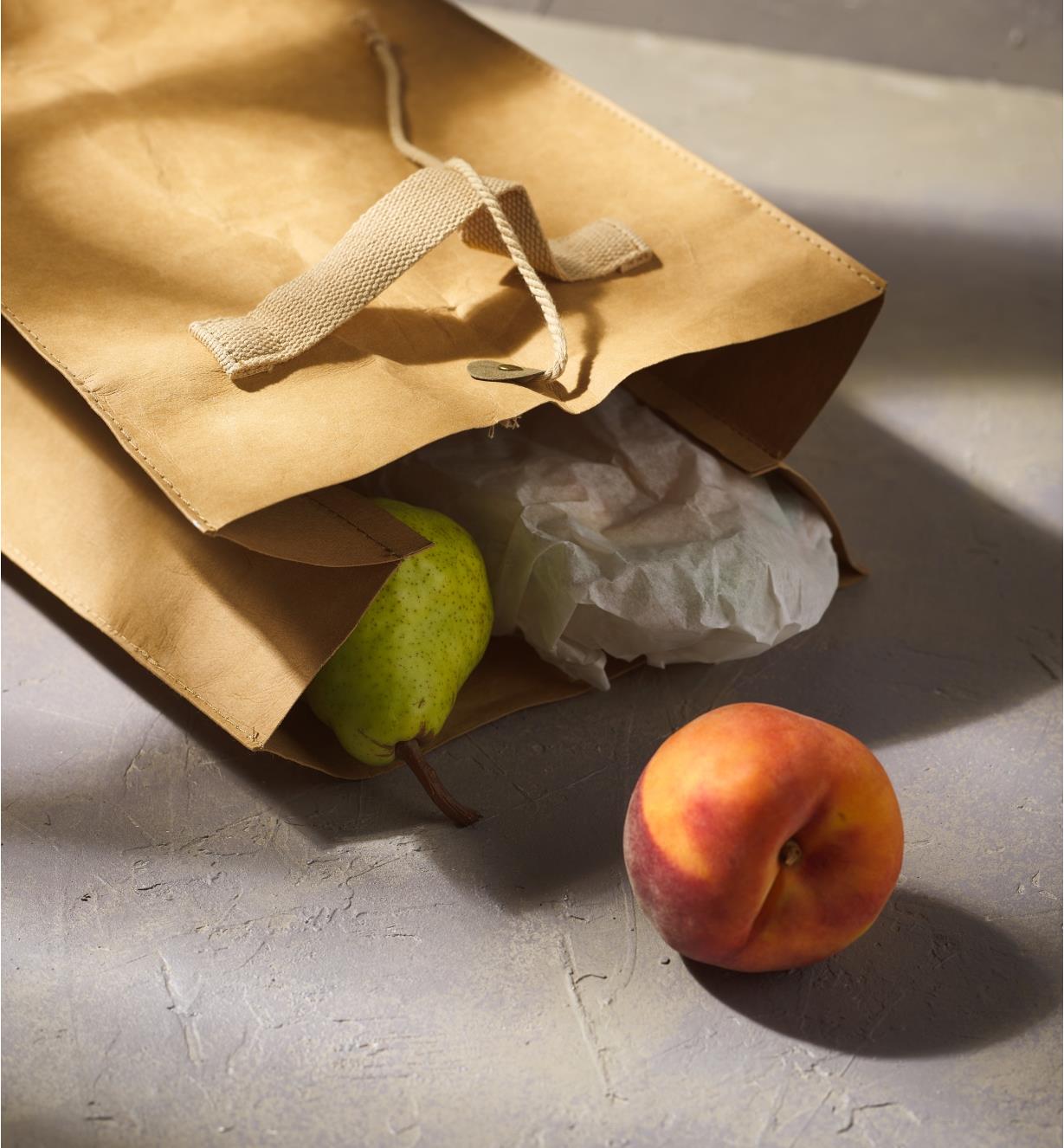 An open tree leather lunch bag lying on its side to dispense the contents
