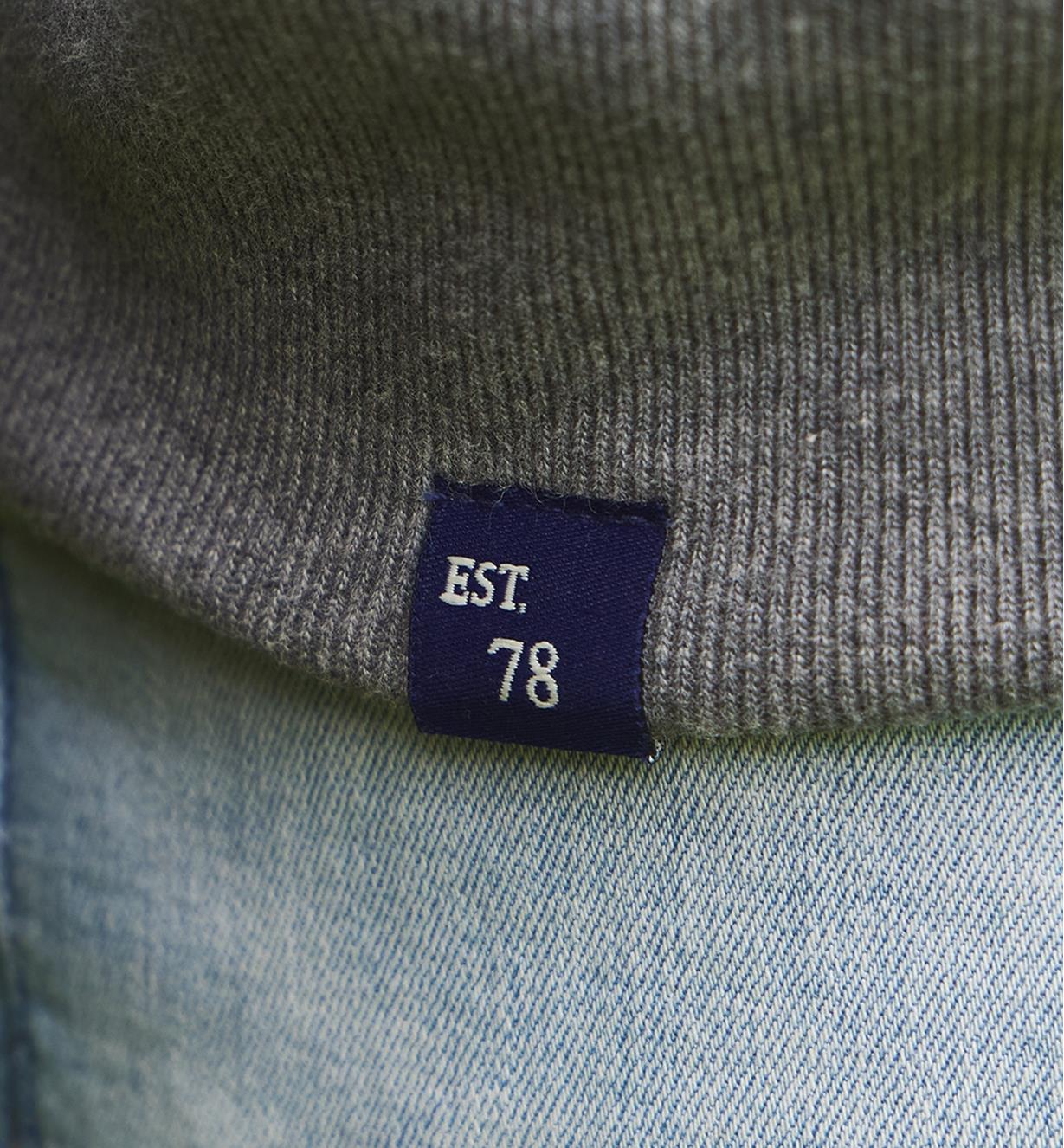 Close-up of Est 78 tag sewn onto bottom of sweatshirt