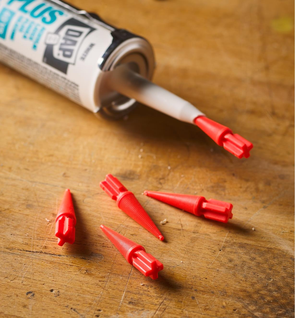 Four Twist-n-Seal stoppers next to one stopper inserted in a tube nozzle
