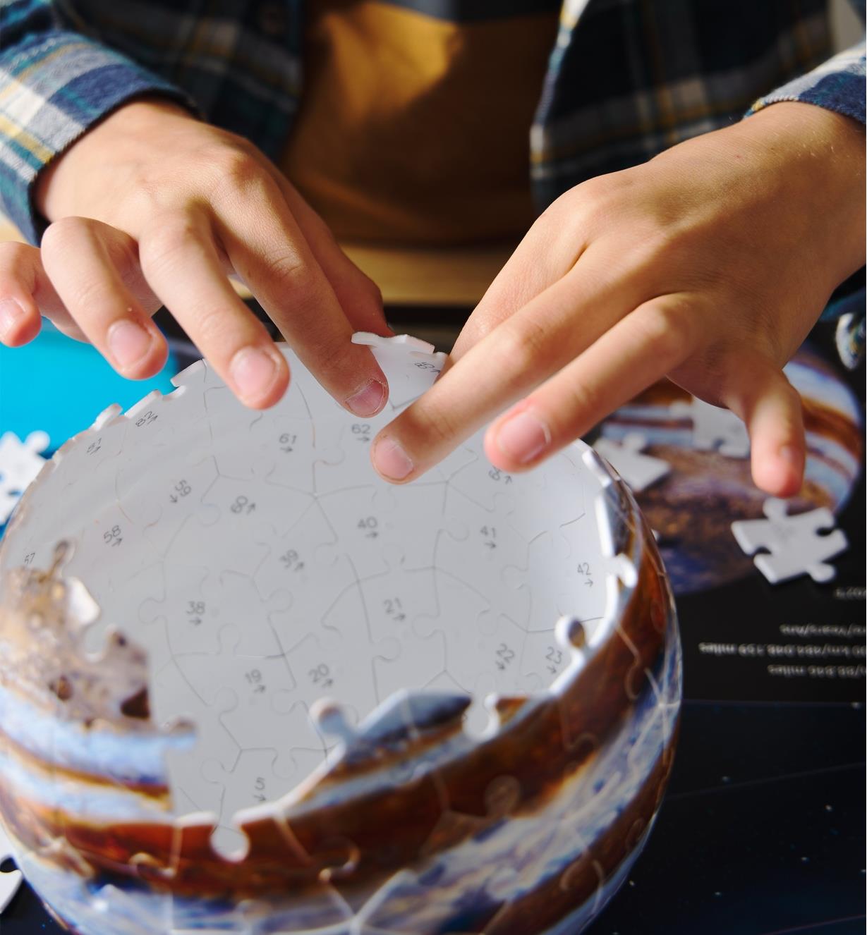 A 3D planet puzzle being assembled with numbers on the inside of the pieces