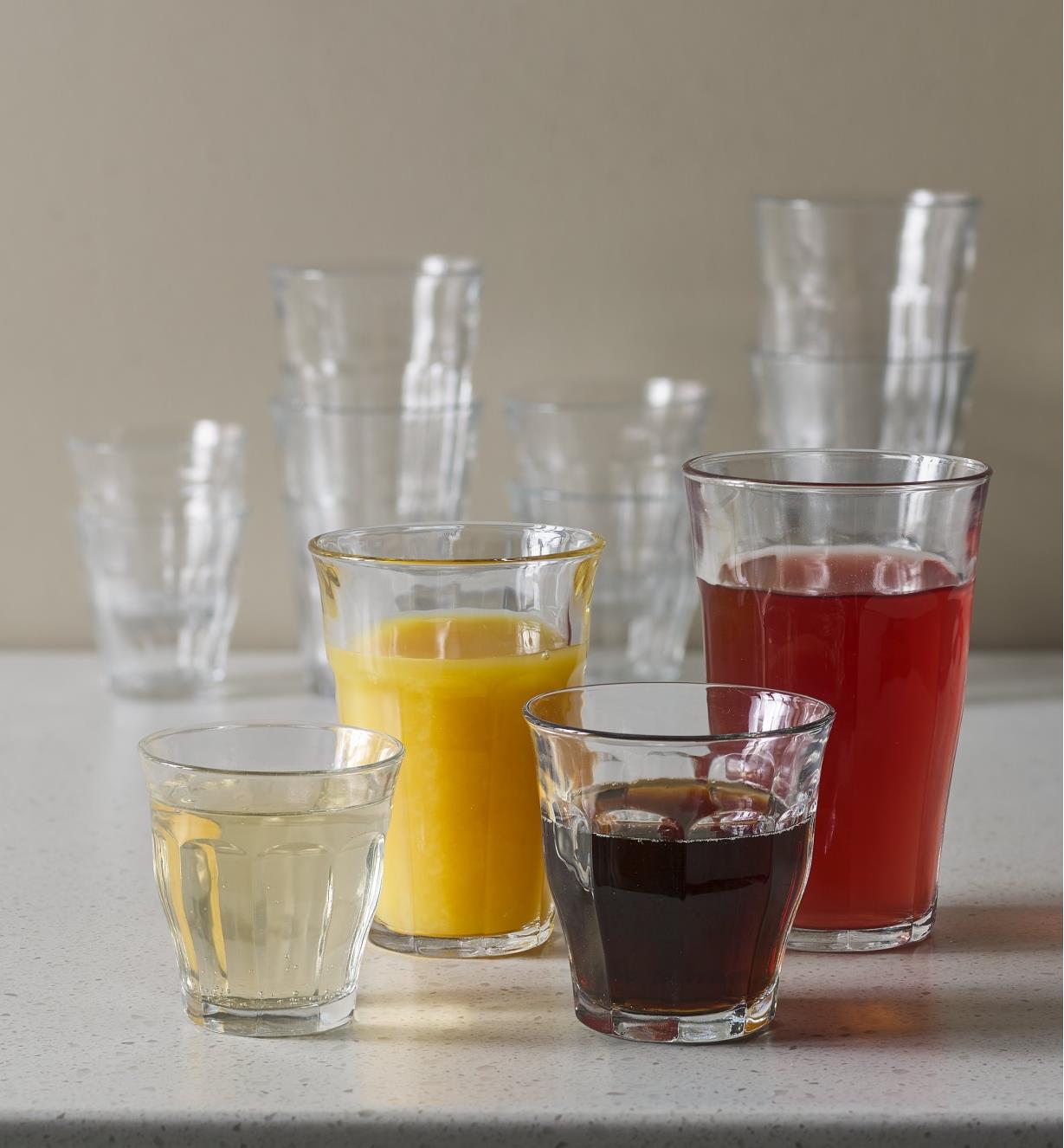 Four Picardie glasses of different sizes with different liquids in them.
