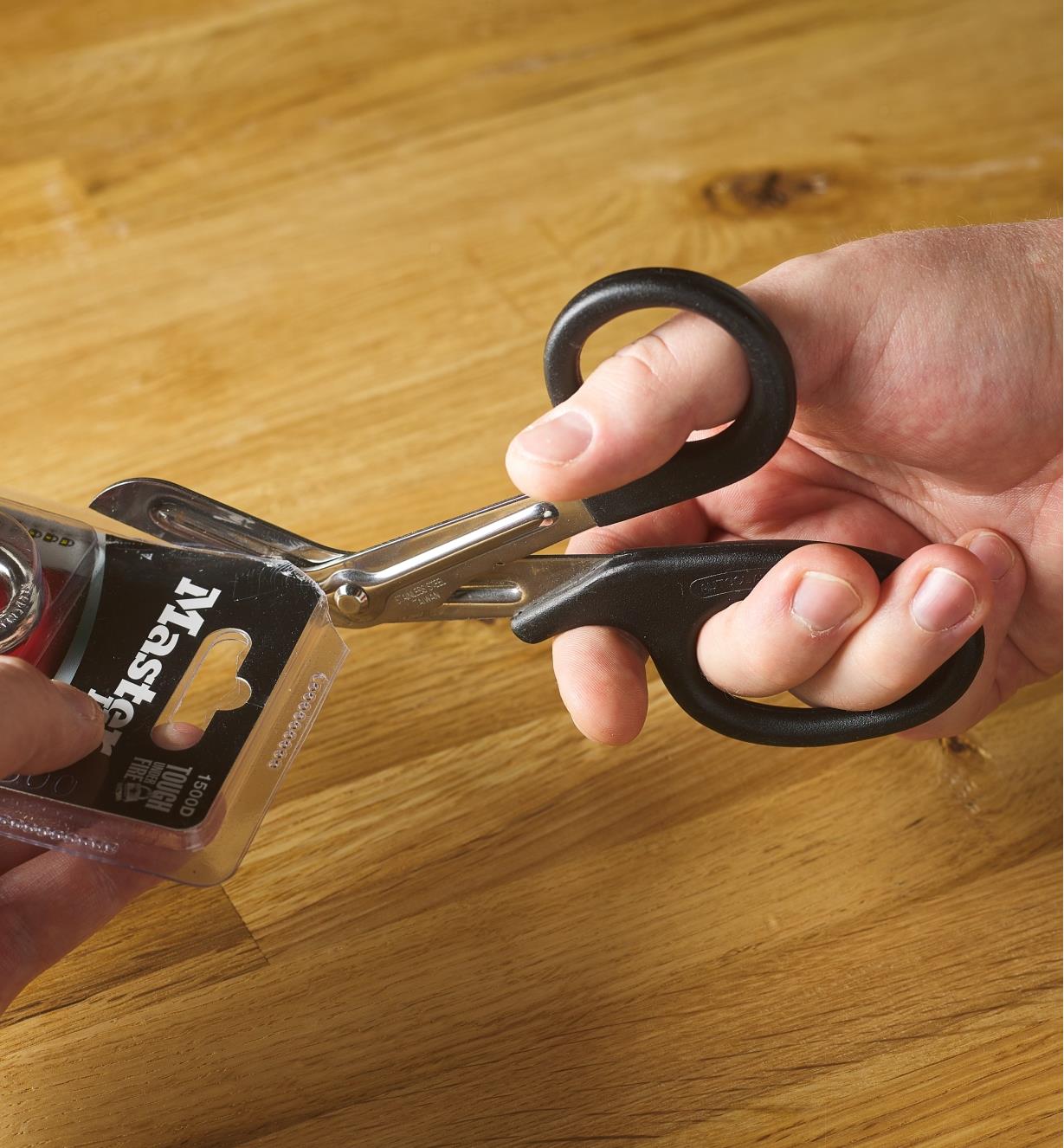 Scissors being used to open plastic clamshell packaging