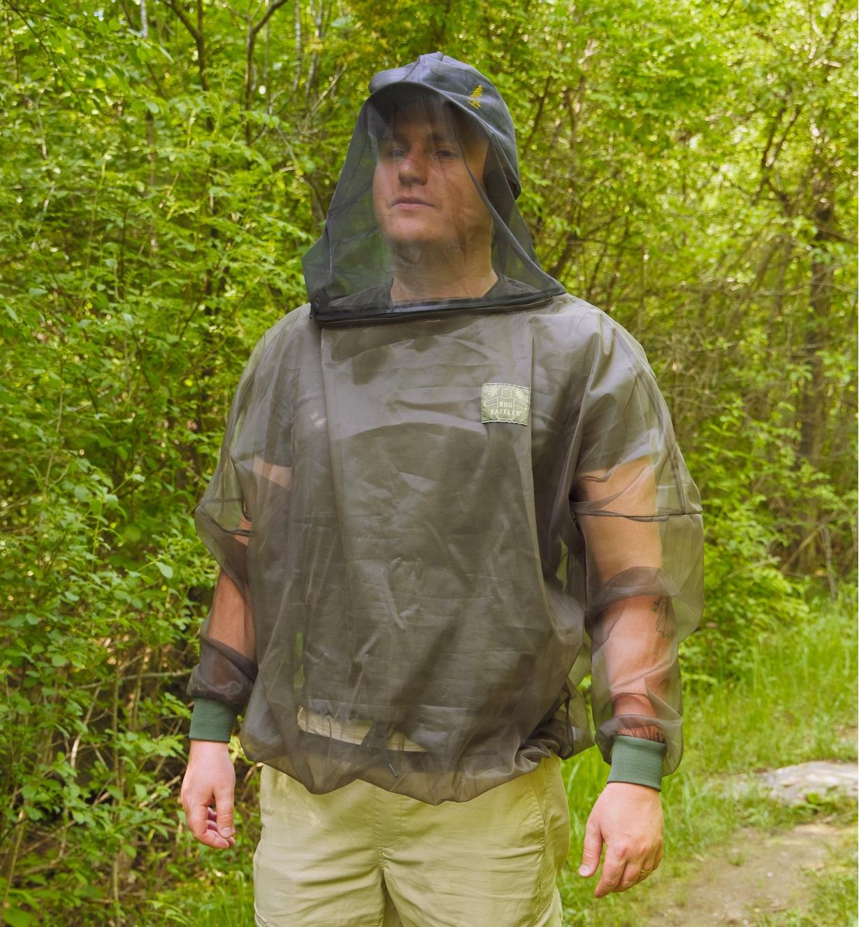A man wears a bug-protection shirt on a hiking trail