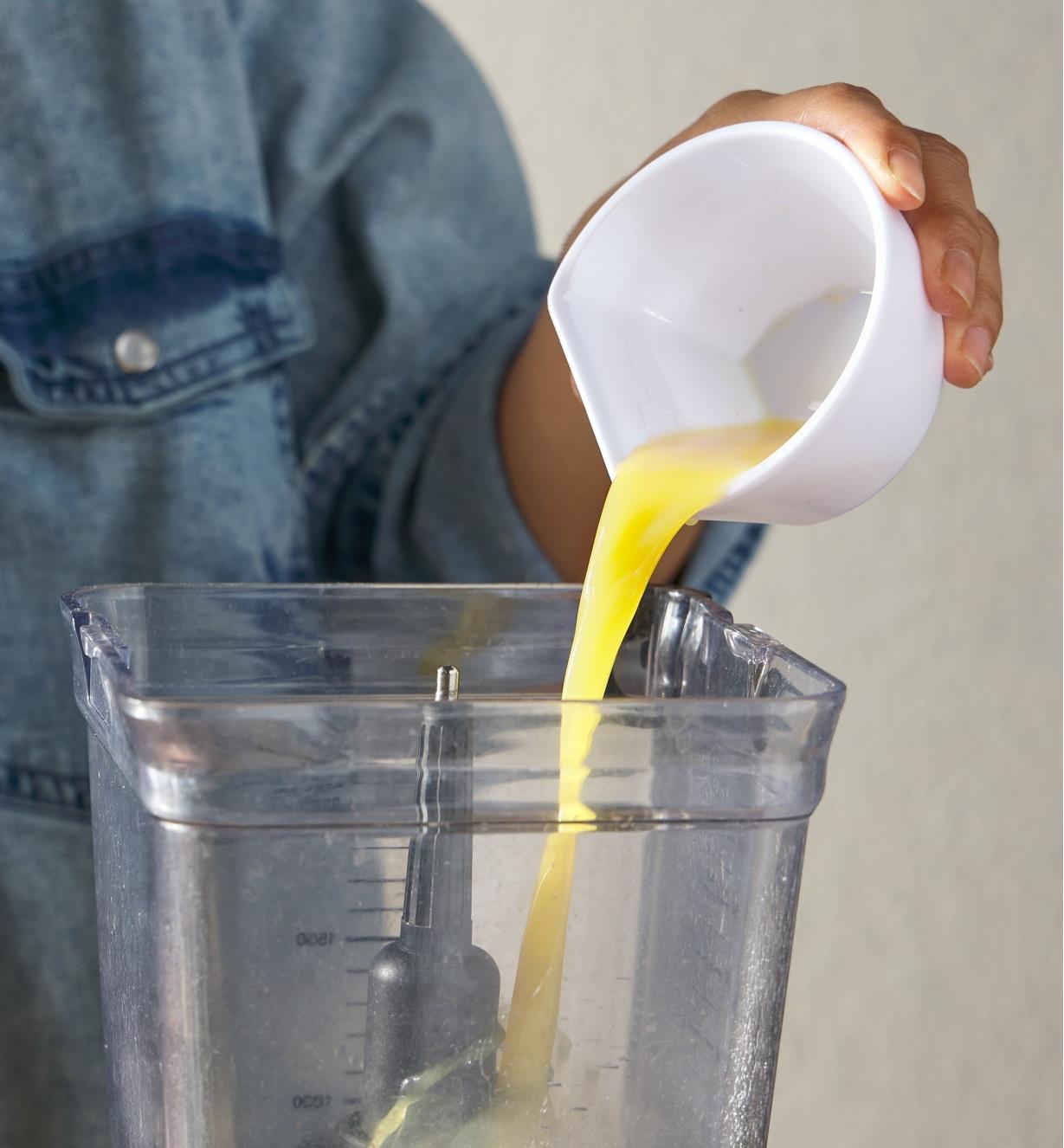 Using one of the corners of the scoop measuring bowl as a spout to pour liquid
