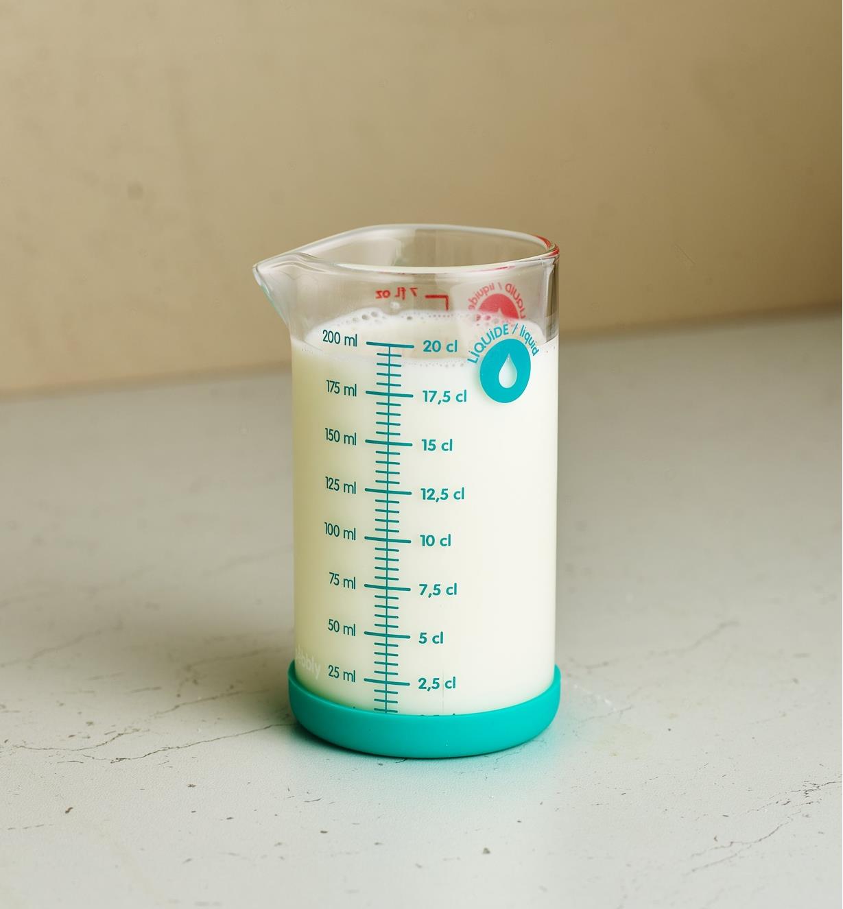 A measuring glass filled with milk