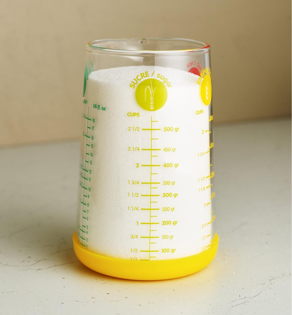A measuring glass filled with sugar