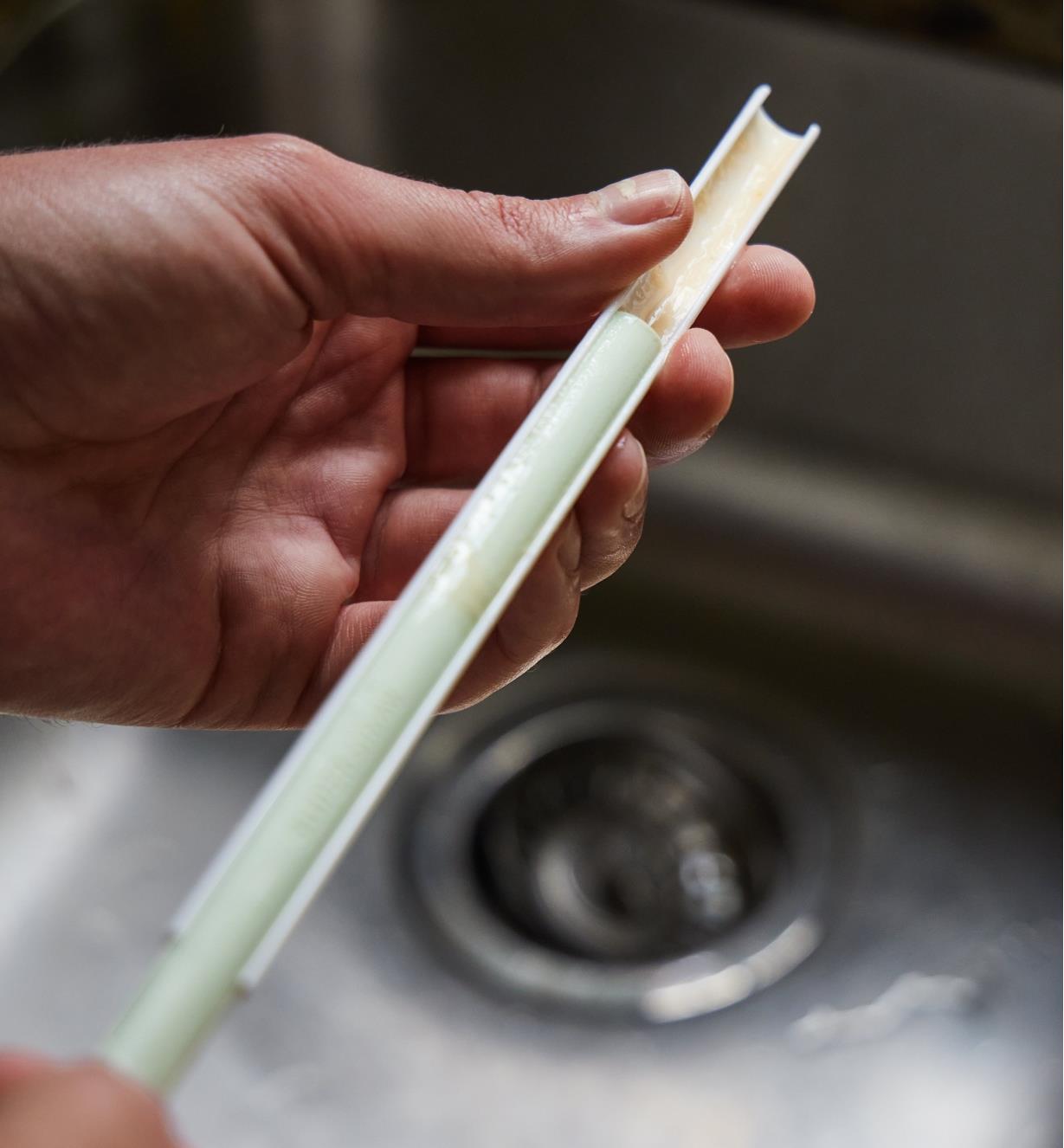 A slider straw being slid apart over a sink