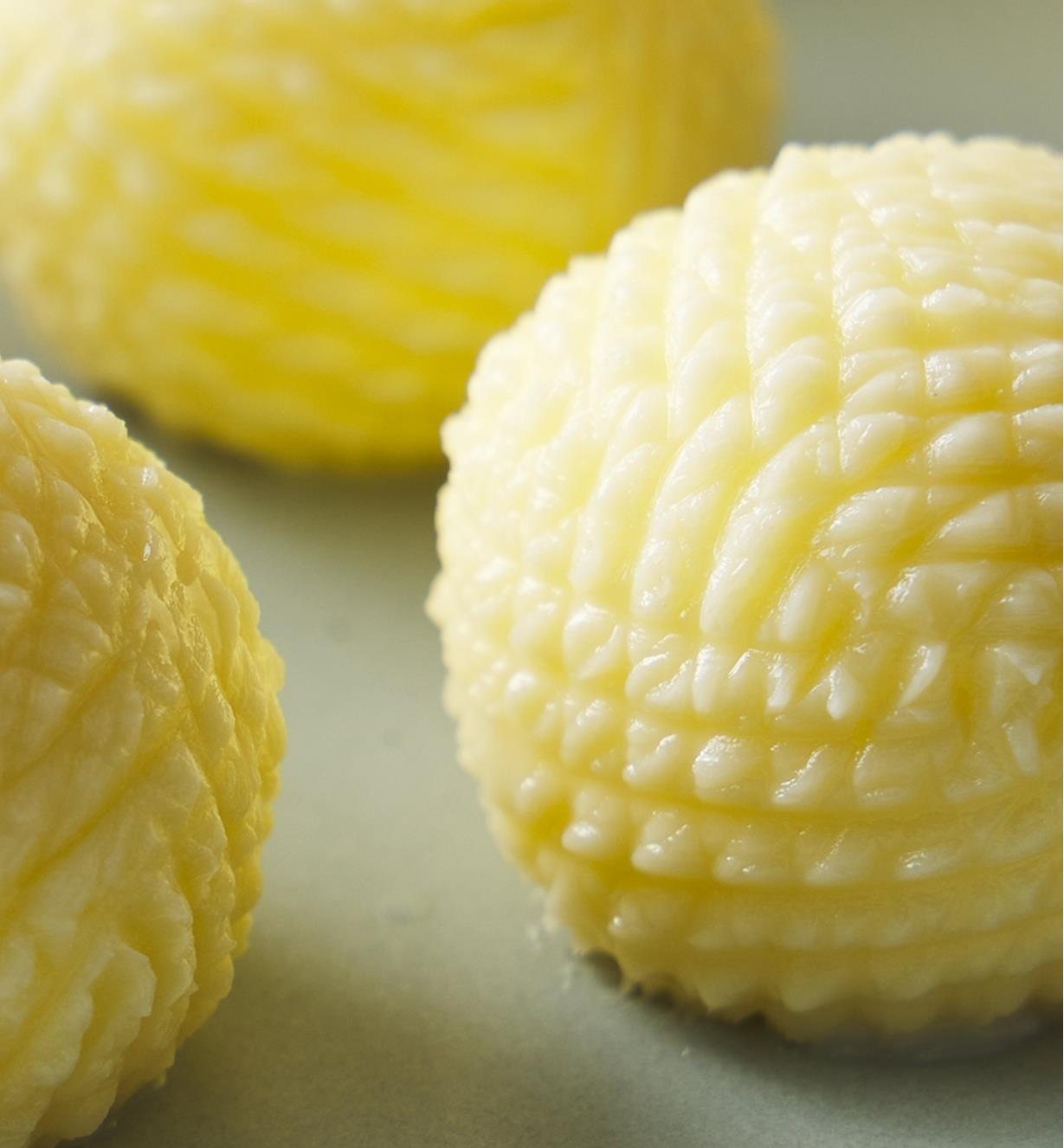 Three decorative, ridged balls of butter.