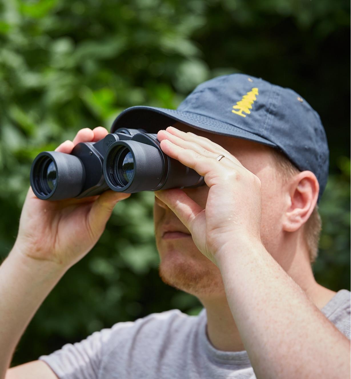 A man looks through a pair of binoculars