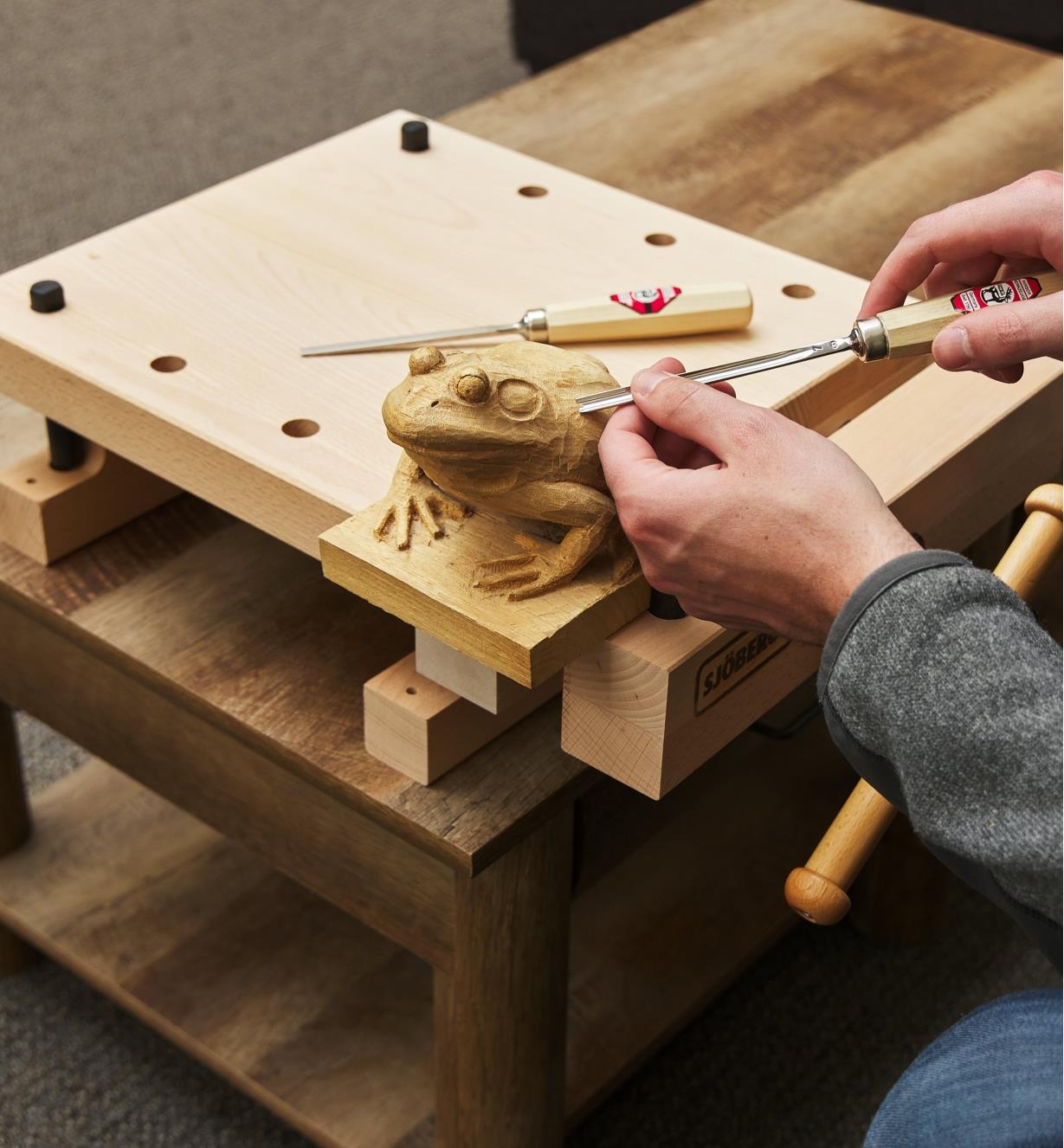 A frog being carved while secured to the workstation using the vise and bench dogs