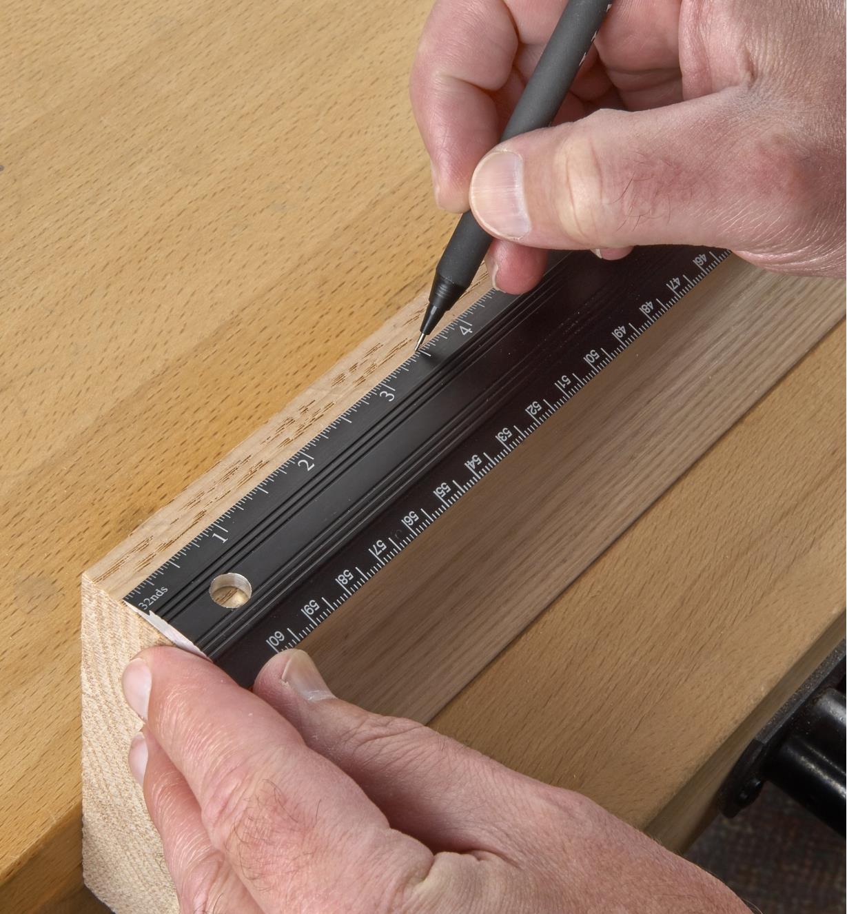 Using a pencil and a Veritas bench rule to mark a cut line on a wooden workpiece