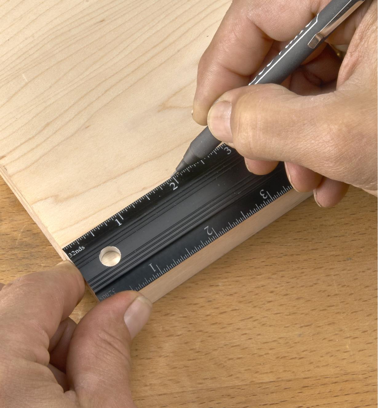 Using a pencil and a Veritas bench rule to mark a cut line on a wooden workpiece